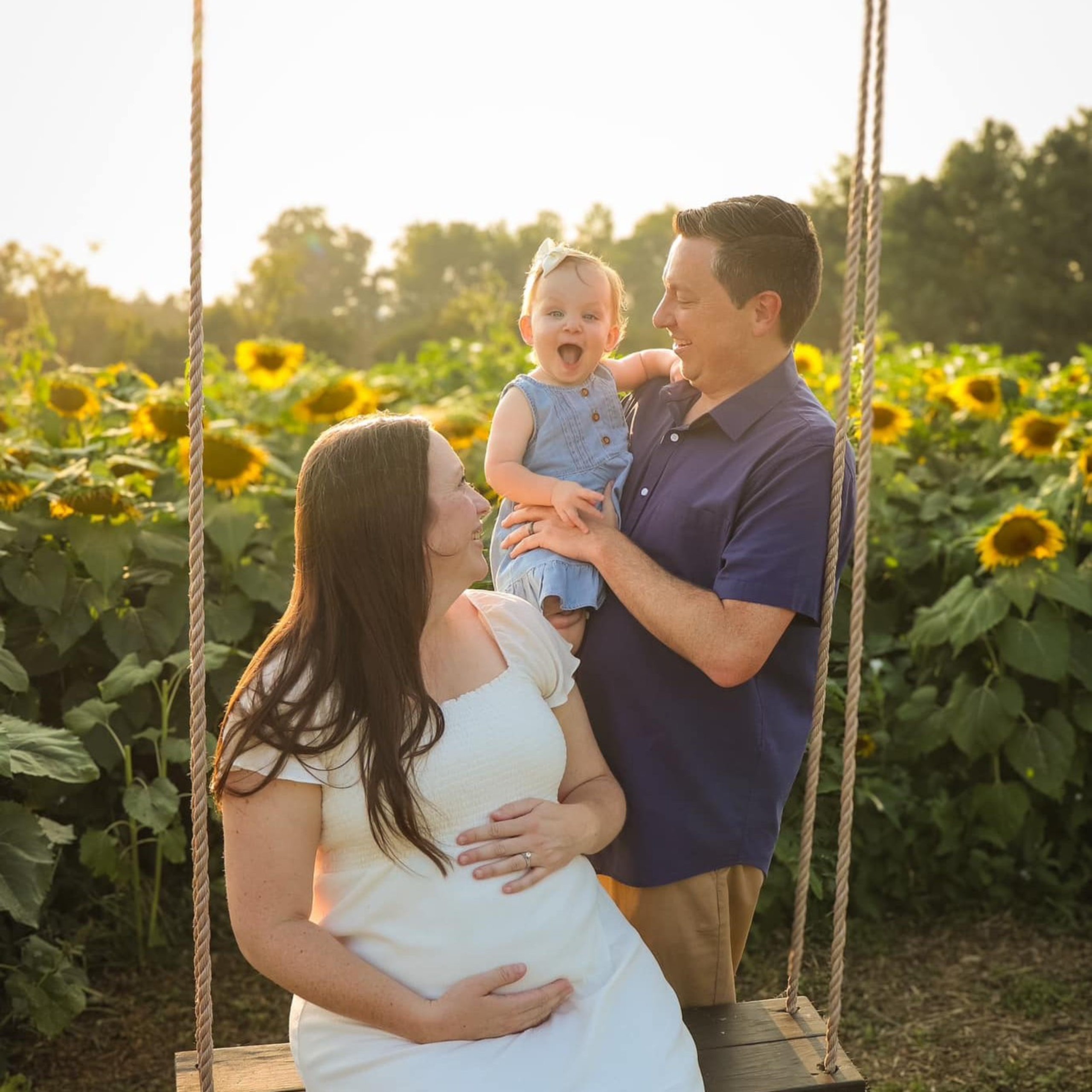 Family on the swing in the sunflower field at Endless View Farms